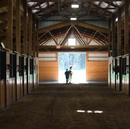 photo of trainer leaving Lenux Stables barn with horse