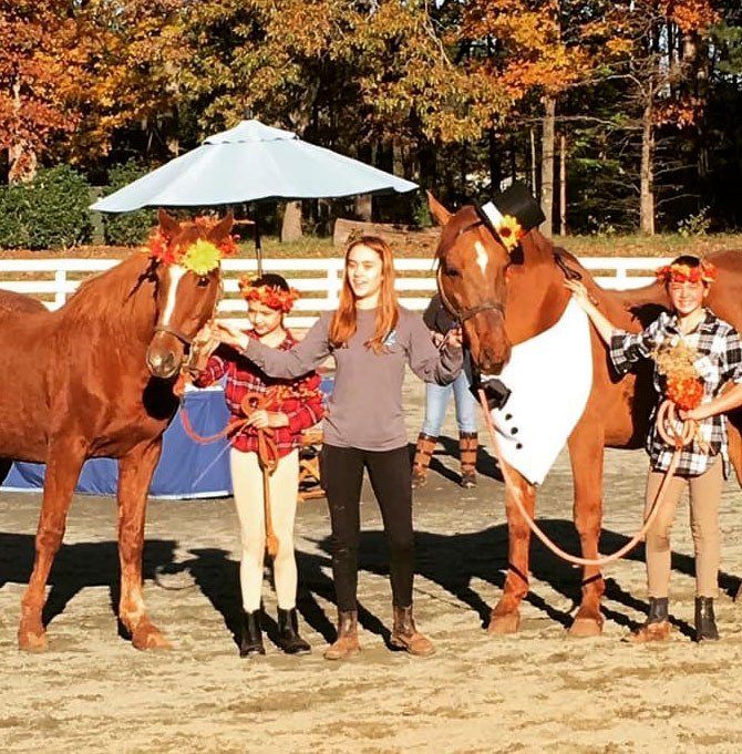 photo of three kids holding horses named 