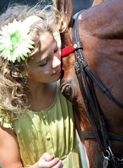 photo of girl with flower in her hair snuggling American Saddlebred horse