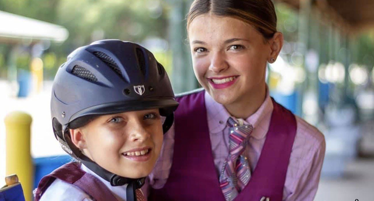 photo of two smiling girls at a horse show