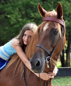photo of girl sitting on and hugging American Saddlebred horse named 