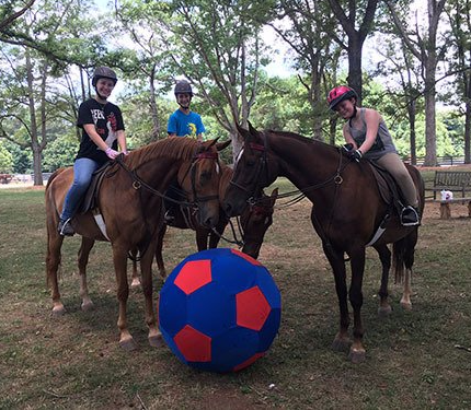 photo of three Lenux campers surrounding giant blue and red soccer ball