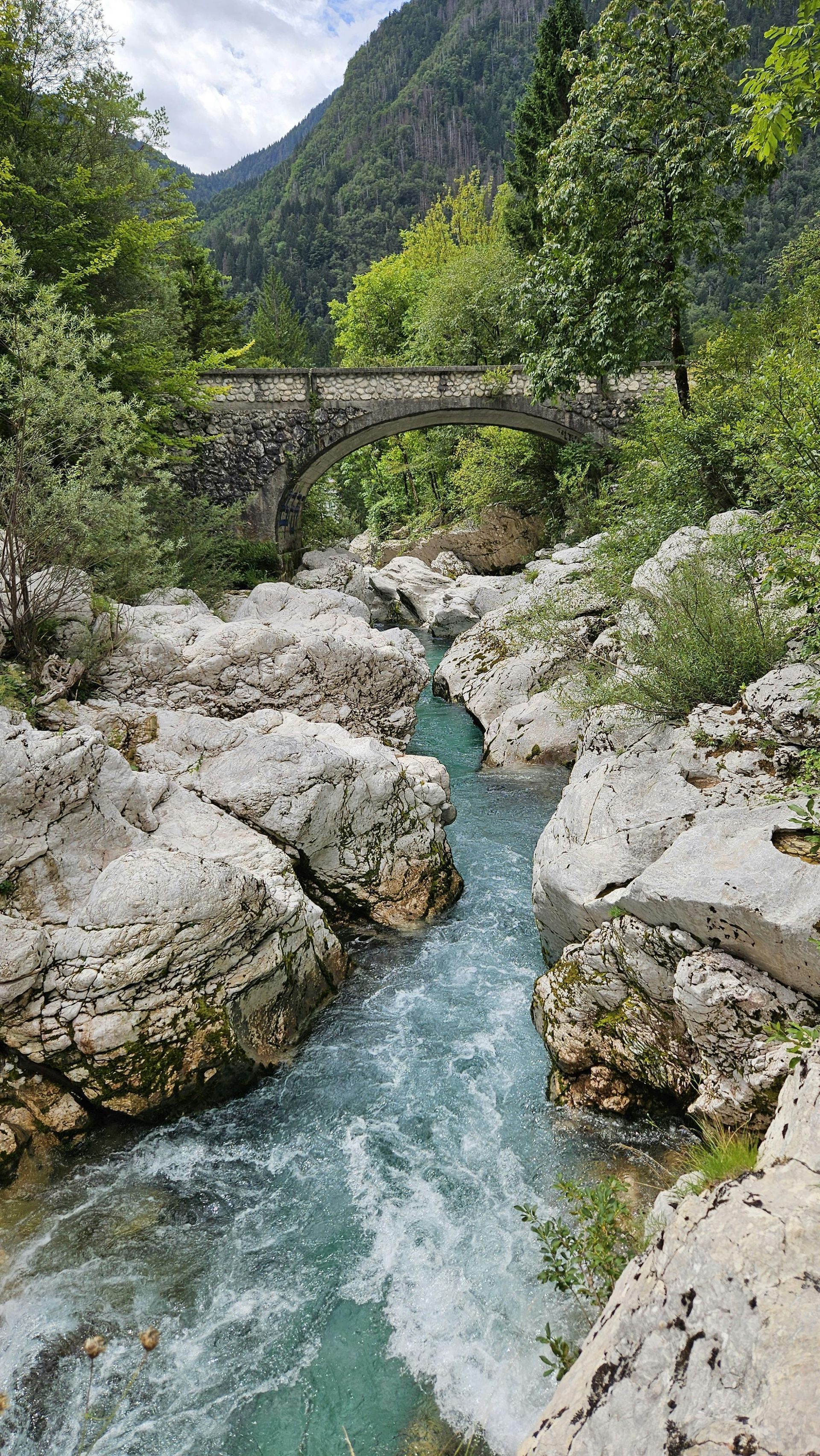 Veduta dal basso di moderni grattacieli di vetro che si stagliano contro un cielo nuvoloso.