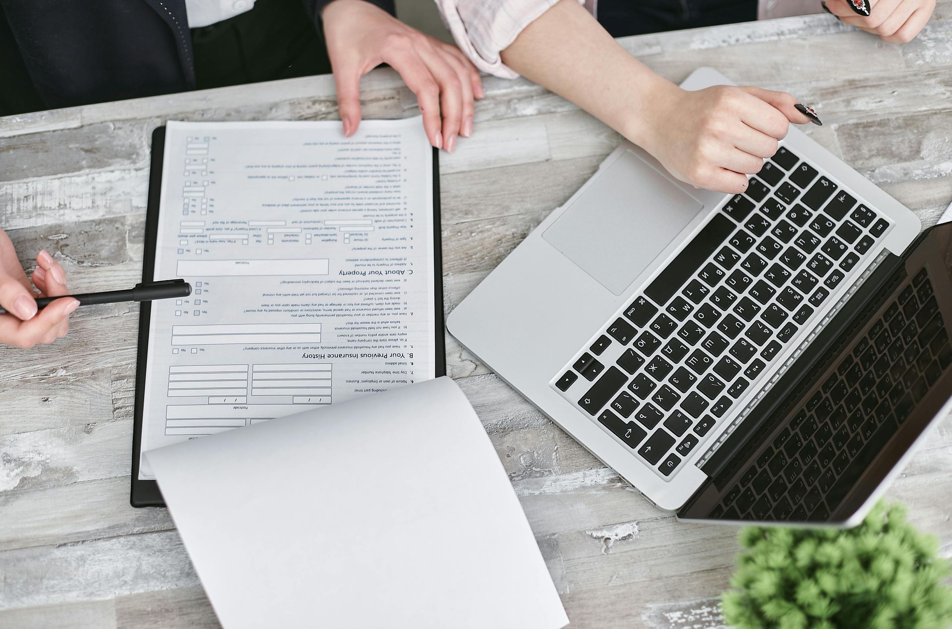 Le sagome di alcuni professionisti del mondo degli affari sono sedute attorno a un tavolo da conferenza di fronte a una grande finestra che si affaccia sullo skyline della città.
