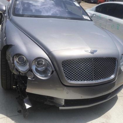 A bentley continental gt is parked on the side of the road.