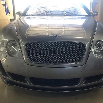 A bentley continental gt is parked in a garage.