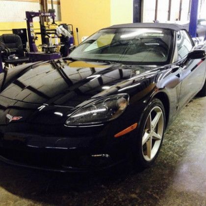 A black sports car is parked in a garage