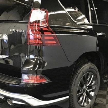 A black lexus gx460 is parked in a garage.