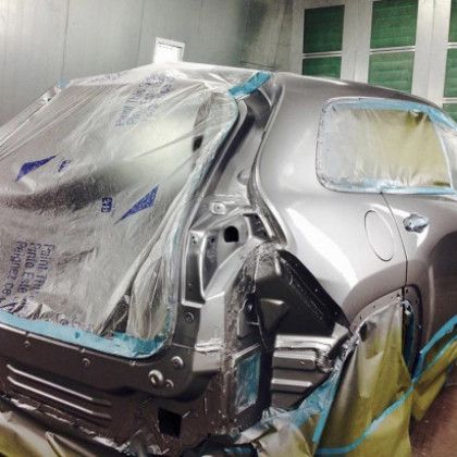 A car is being painted in a paint booth.