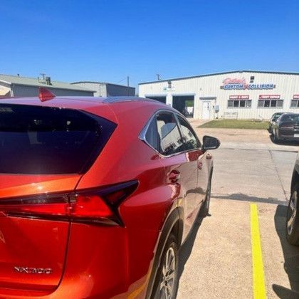 A red lexus nx300 is parked in a parking lot.