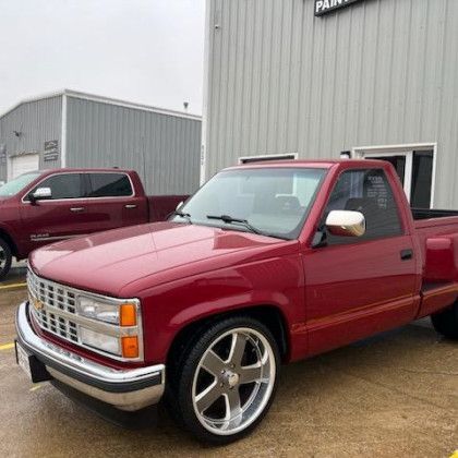 A red truck is parked in front of a building.