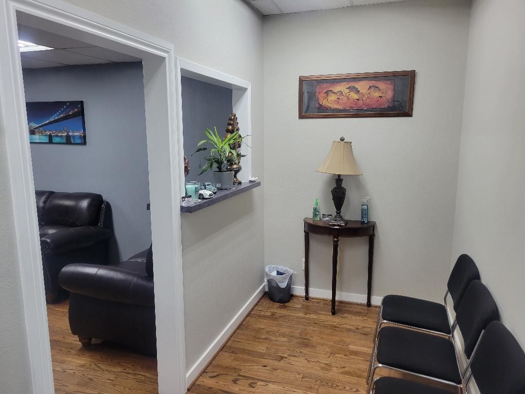 A waiting room with chairs, a table and a lamp.