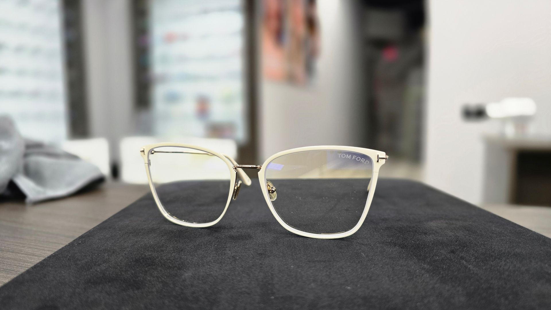 Gold-rimmed eyeglasses on a black surface in a shop.