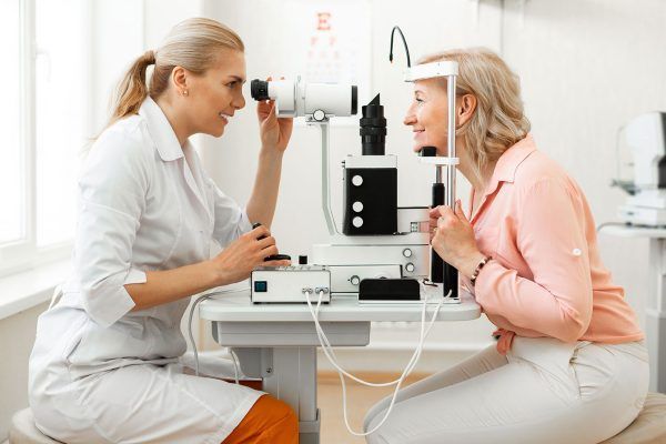 A woman is getting her eyes examined by an ophthalmologist.