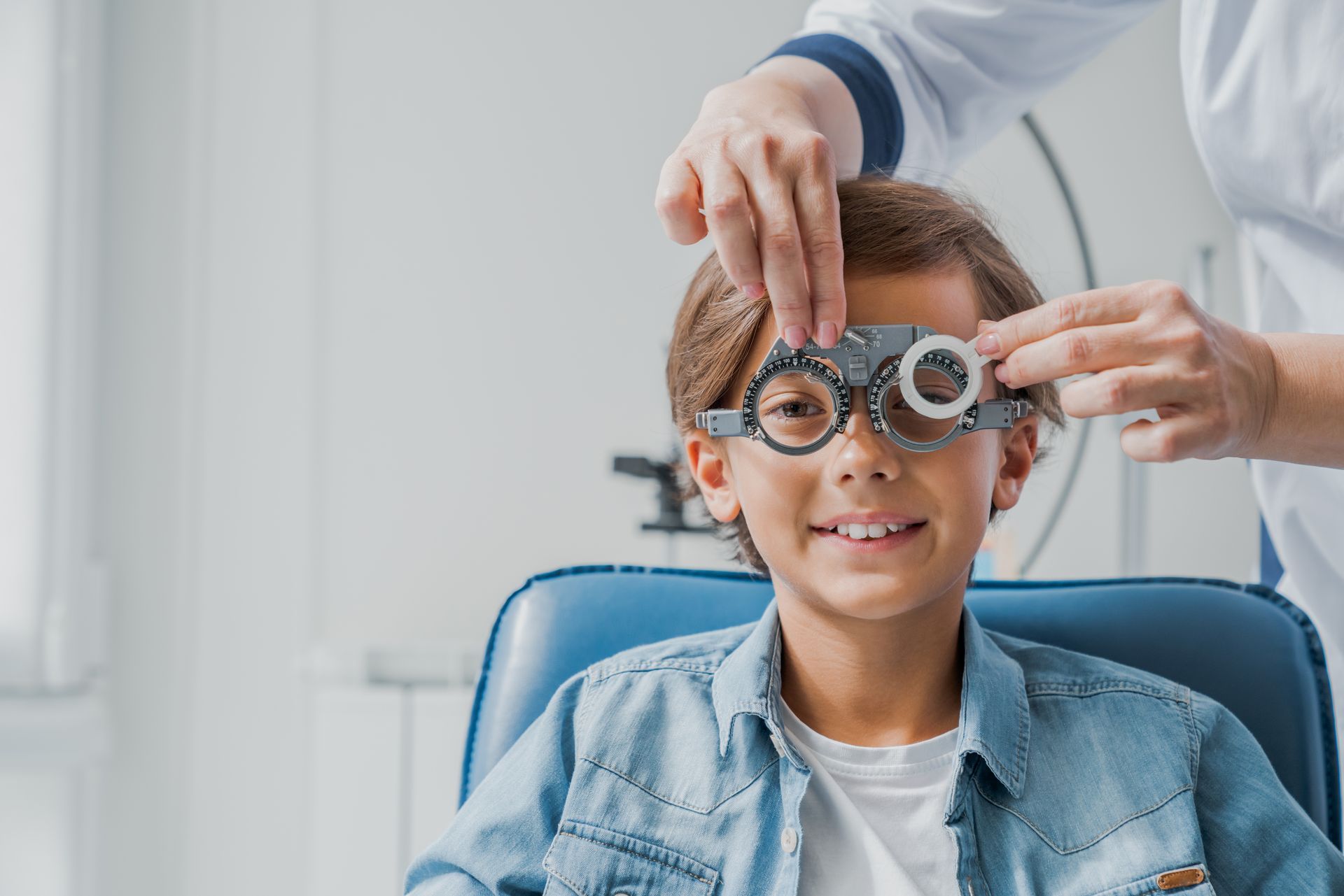 A young boy is getting his eyes checked by an ophthalmologist.