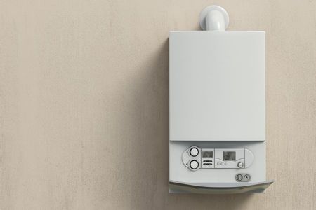 Brand-new white gas boiler, installed on a magnolia wall.