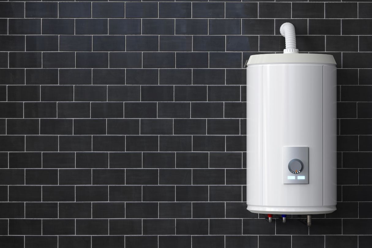 A large white gas boiler in a room with black tiles on the wall.