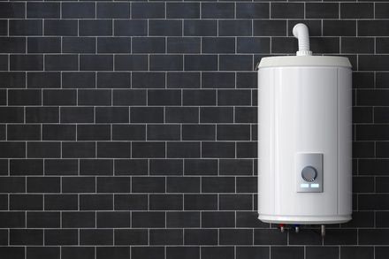 A large gas boiler installed on a black tiled wall.