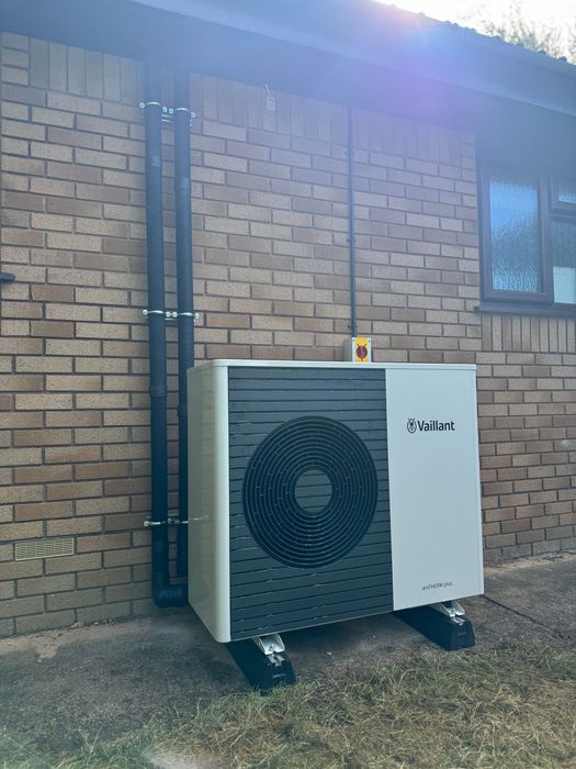 New Vaillant heat pump installation Exeter against a red brick wall.