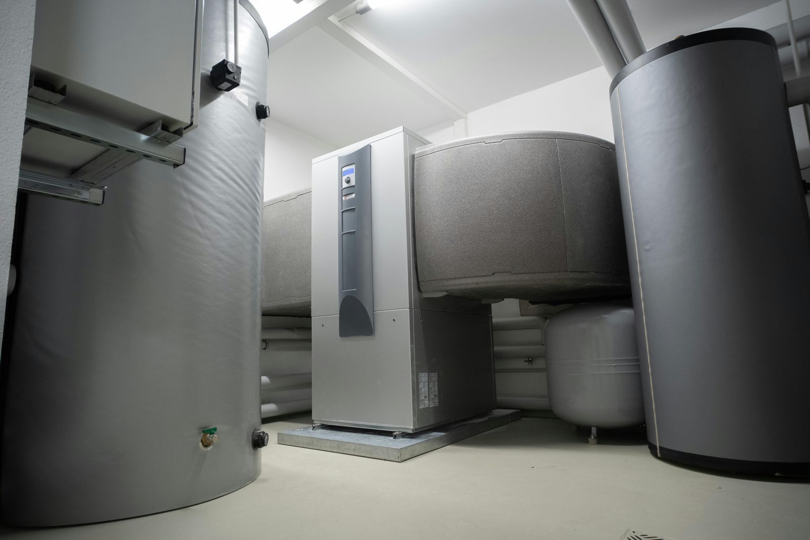 A room with a lot of gray cylinders and a gray heater.