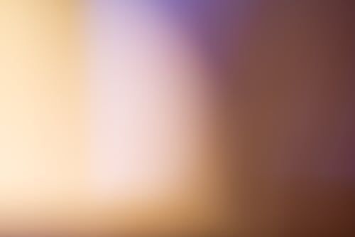 A close up of a blurred background with a purple and yellow gradient.