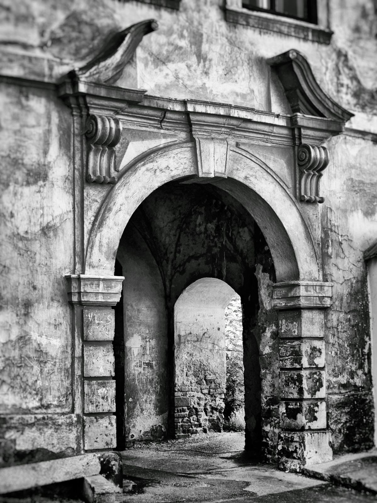 A black and white photo of a stone archway in a building.