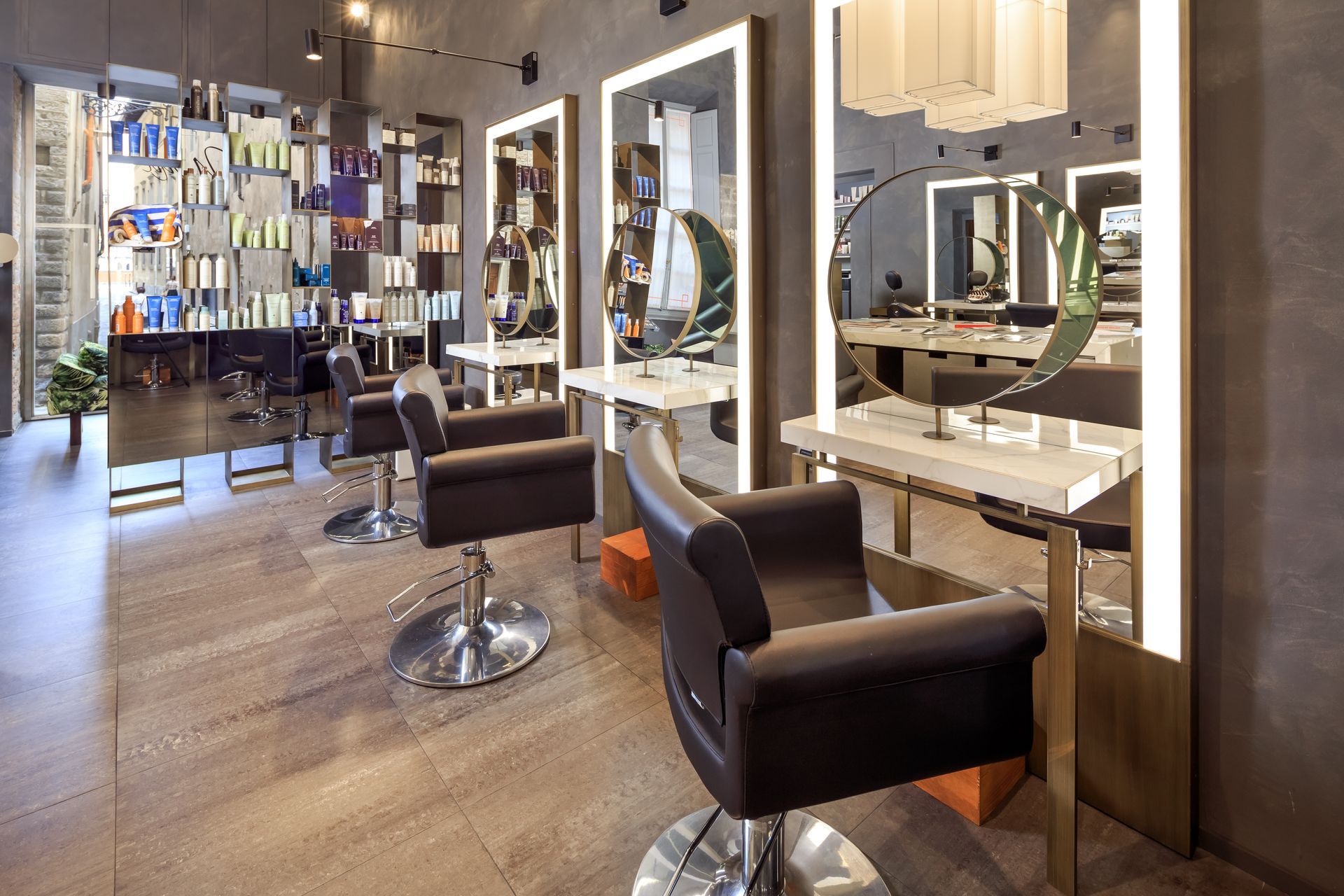 Interno di un salone da parrucchiere con specchi, poltrone per lo styling ed espositori per i prodotti.