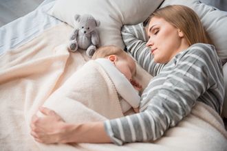 neomamma e neonato dormono sul letto
