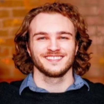 A man with long hair and a beard is smiling for the camera