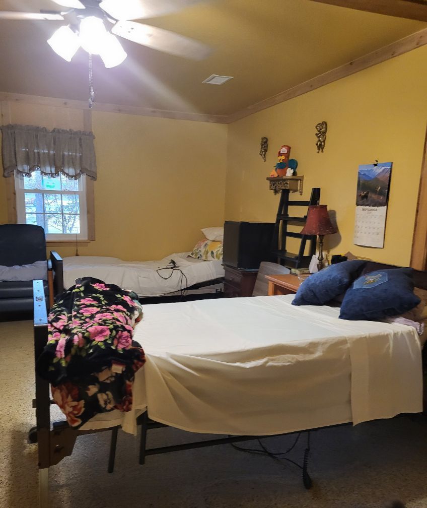 A bedroom with two beds and a ceiling fan