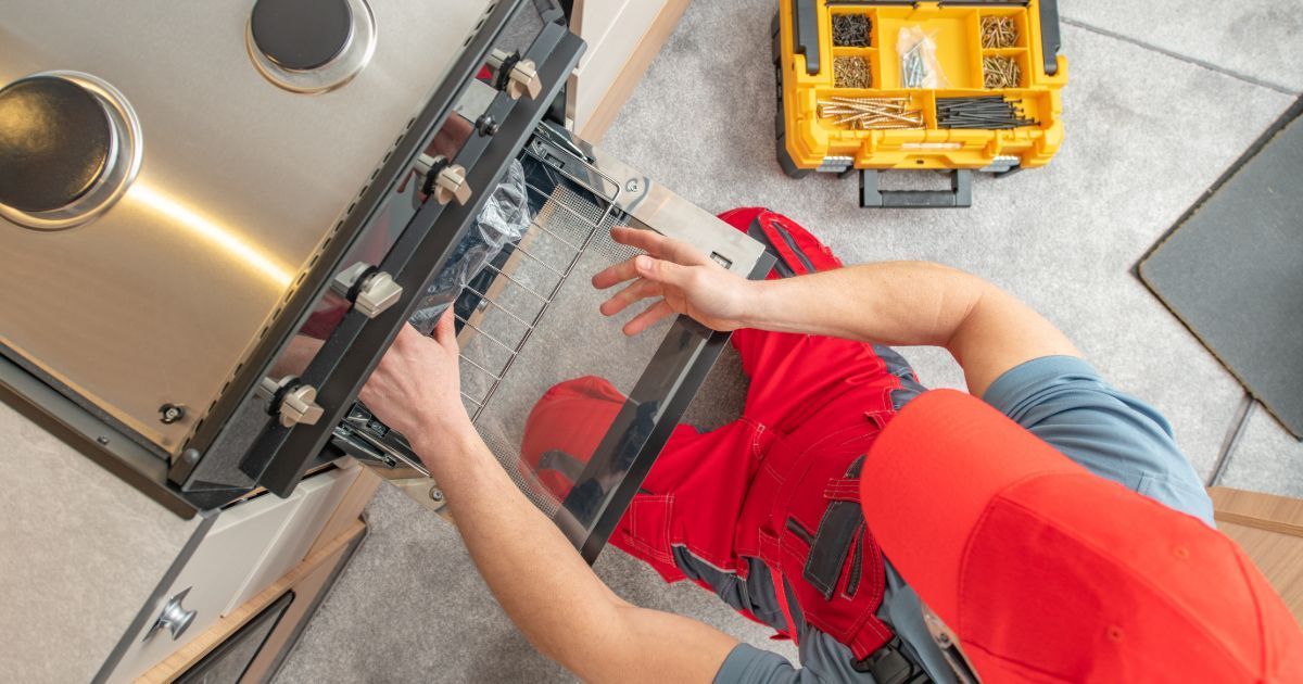 A man is cleaning the roof of a van with a sponge.