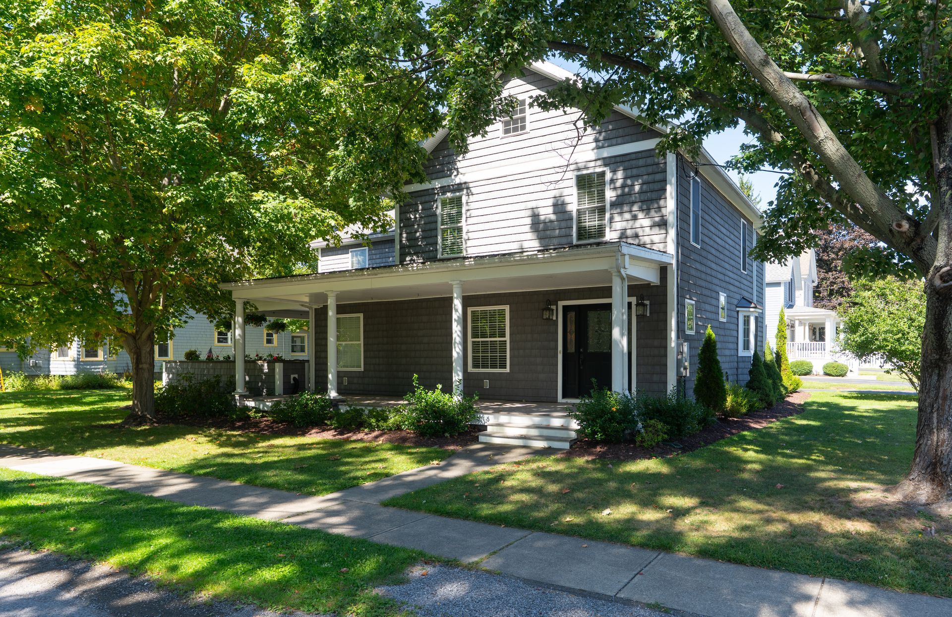 Bedroom with a white bed, nightstand, and wardrobe, light blue walls, and tan carpet.