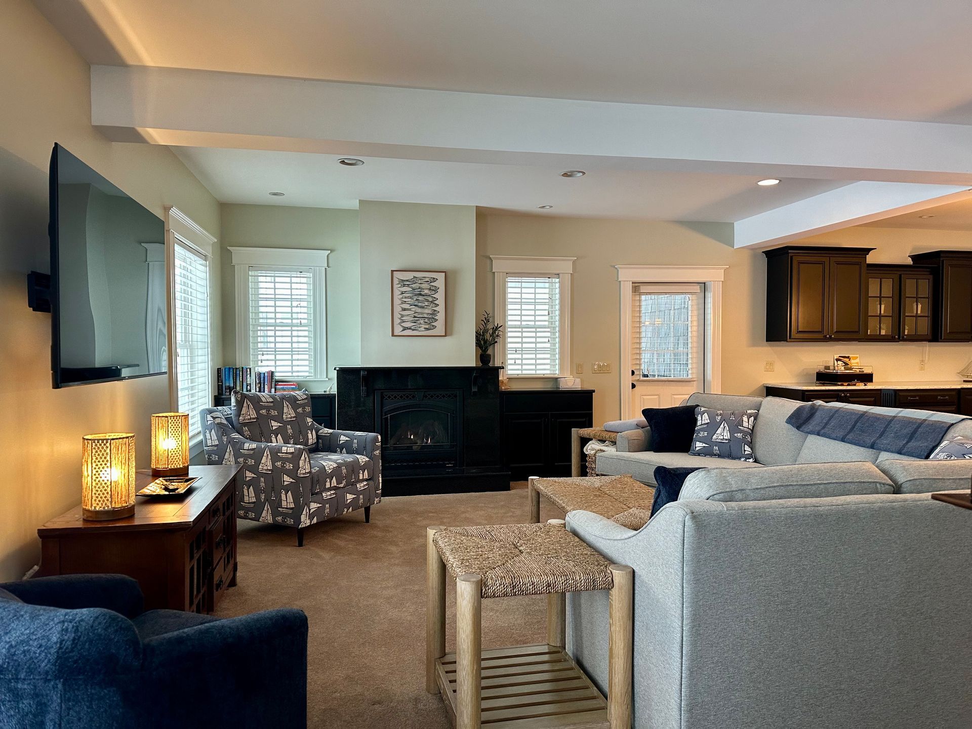 Spacious living room with a gray sectional sofa, fireplace, and two side tables with lamps.