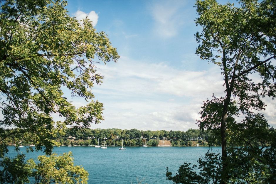 Bedroom with a double bed, nightstand, lamp, and window with blinds. Blue walls, beige carpet.