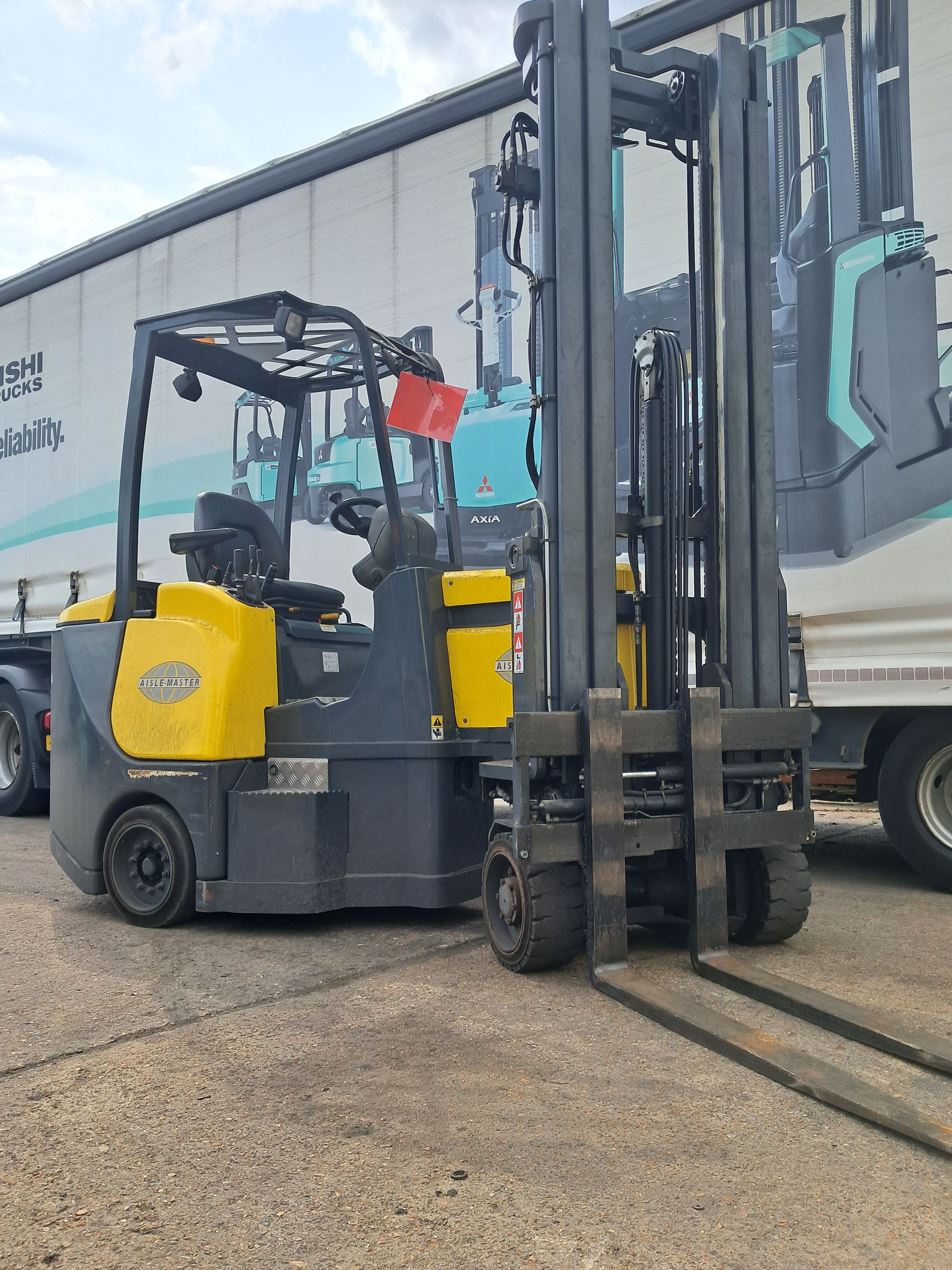 A green forklift is parked on the side of the road.