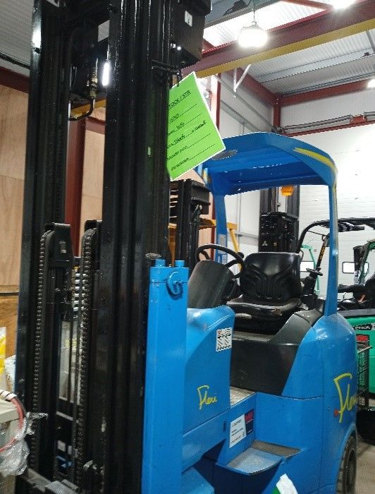 A red forklift is parked in front of a building