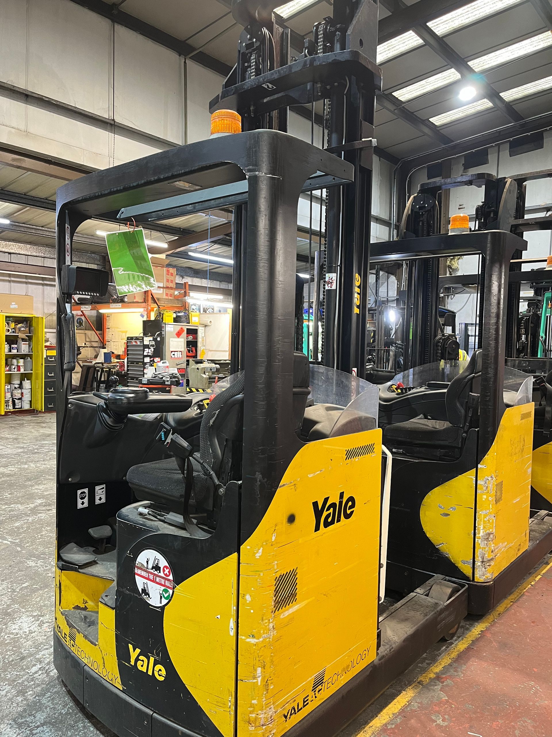 A yellow and black forklift is parked in a warehouse.