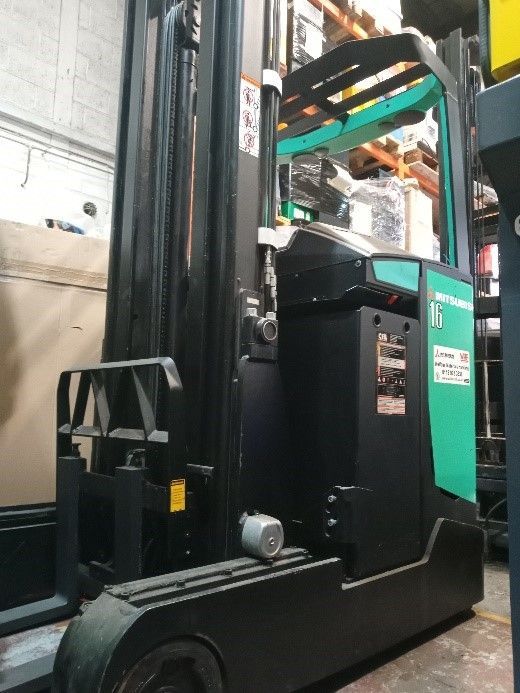A forklift is parked in front of a wmh truck