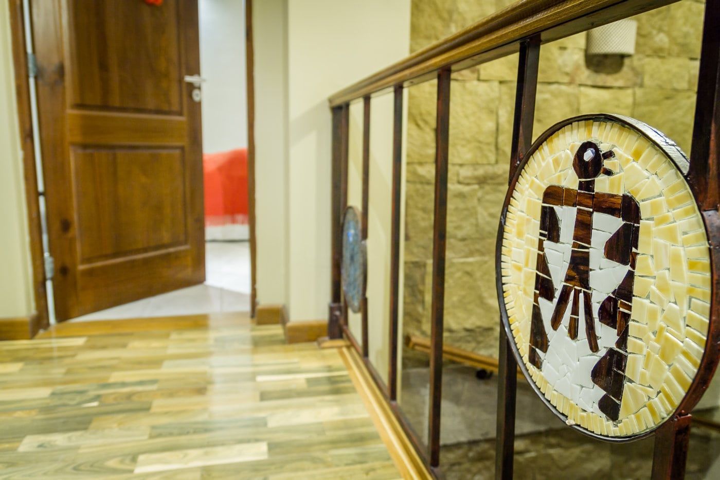 Una escalera con un cuadro en la barandilla y una puerta al fondo.