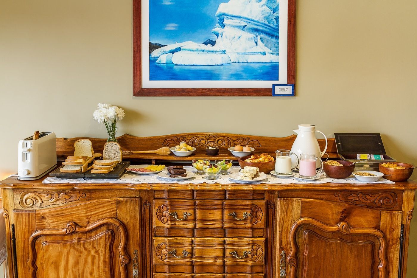 Hay una foto de un barco en la pared encima de la mesa del buffet.