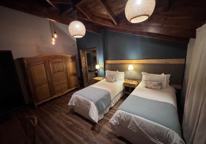 Un dormitorio con dos camas, un armario y un espejo.