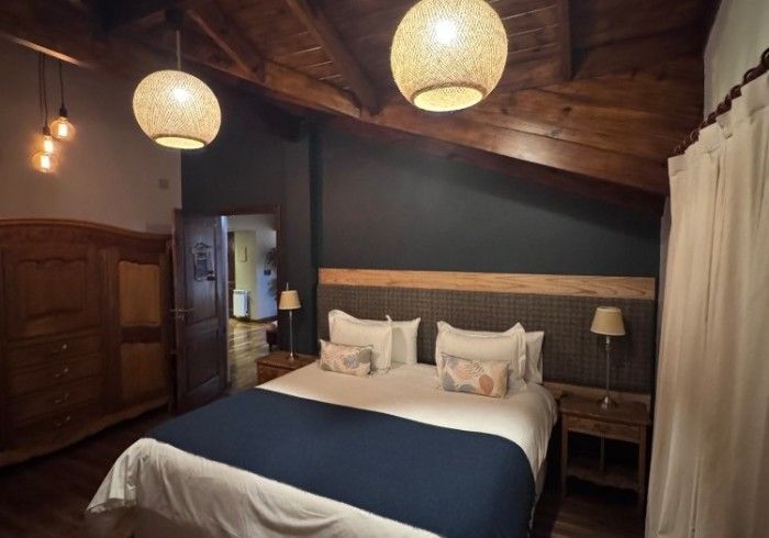 Un dormitorio con una cama king size y dos mesitas de noche.