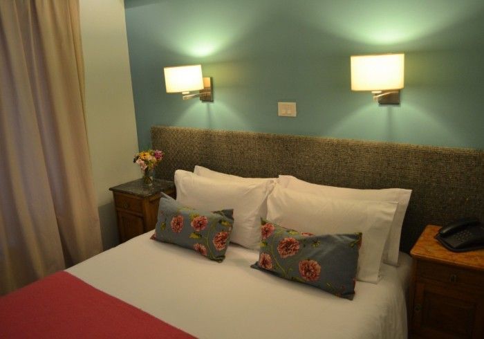 Una habitación de hotel con una cama y dos luces en la pared.