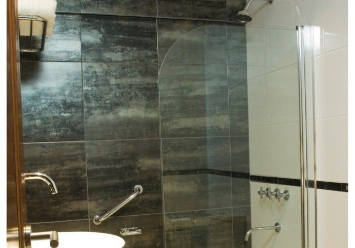 Un baño con lavabo y ducha a ras de suelo.