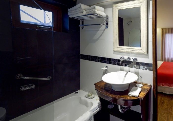 Un baño con lavabo, bañera y espejo.
