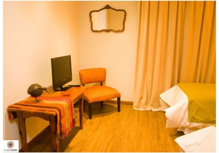 Un dormitorio con dos camas, una silla y una computadora.
