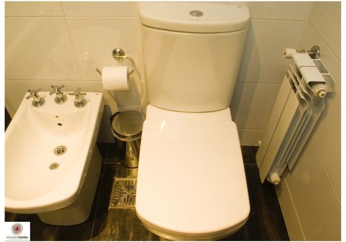 Un baño con inodoro, bidé y radiador.