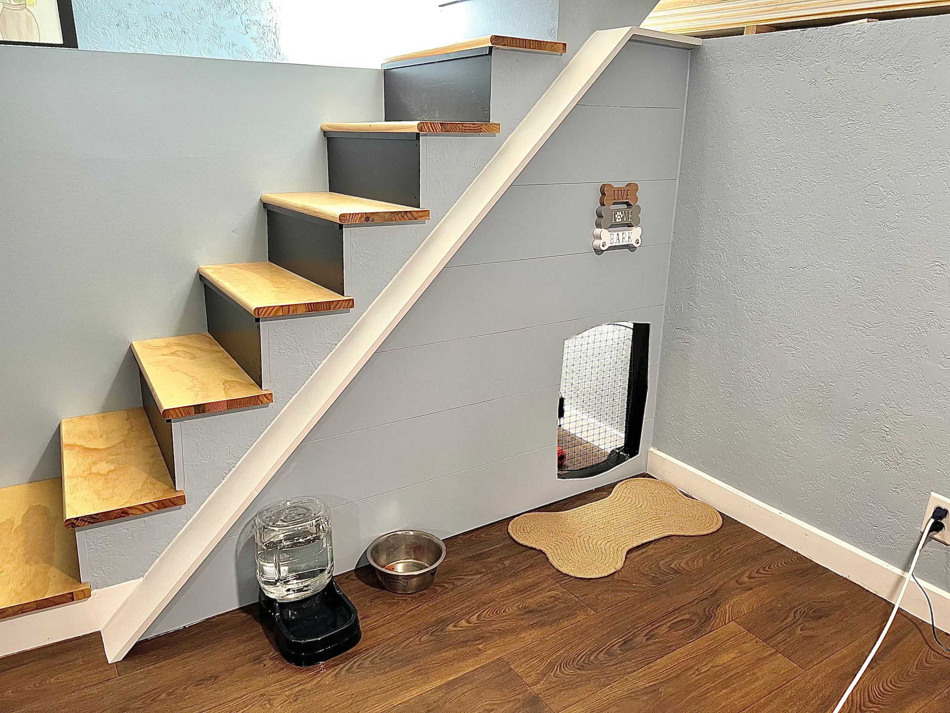 A room with stairs leading up to a dog house