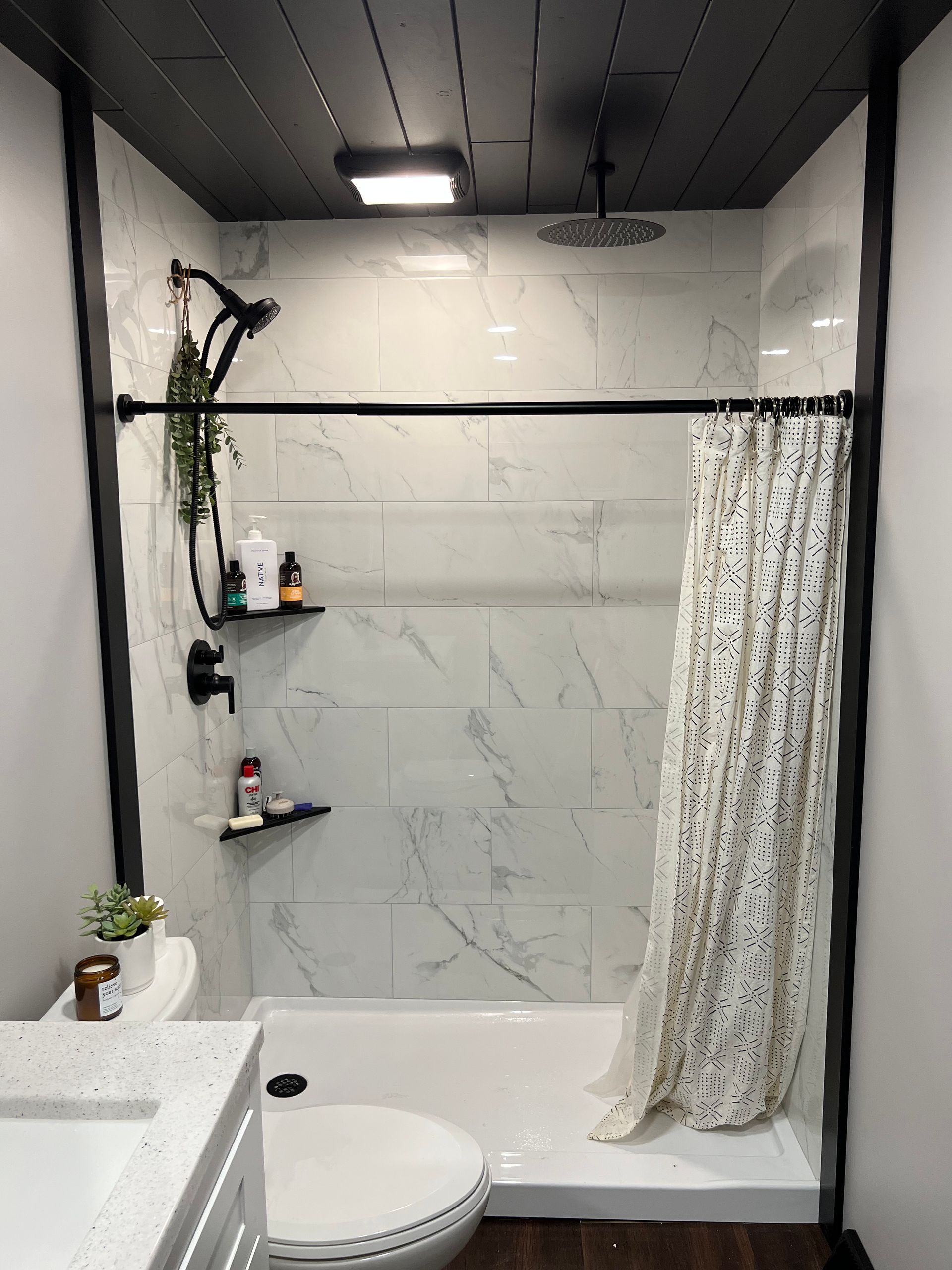 A bathroom with a shower , toilet , sink and shower curtain.