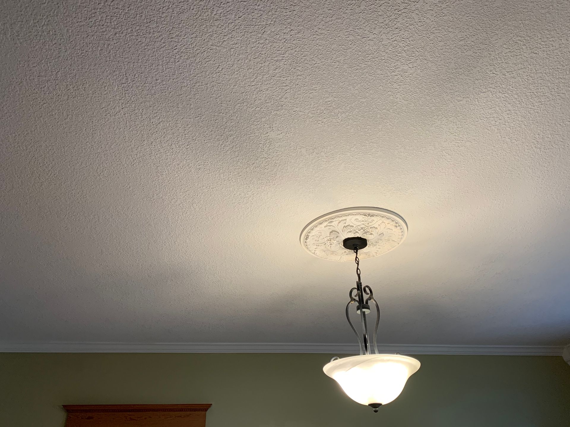 A light fixture is hanging from the ceiling in a room.